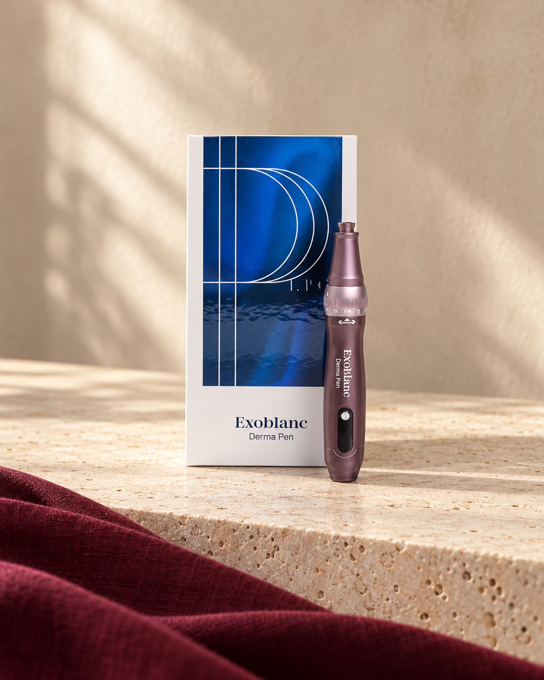 Styled Exoblanc Derma Pen with its box on cream stone and burgundy linen
